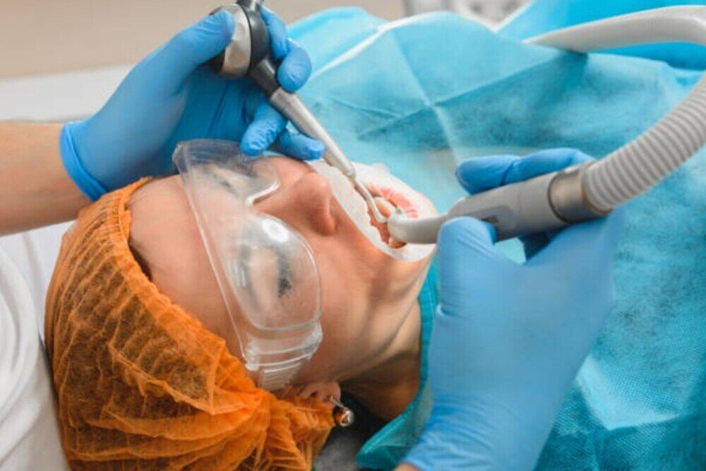 paciente en tratamiento de higiene dental con proteccion y dentista en clinica tres olivos